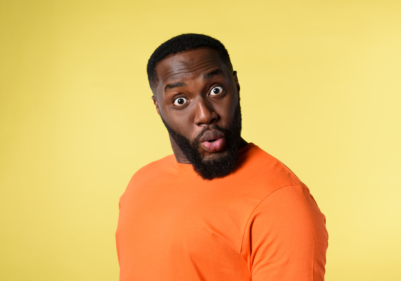 Black Man with Surprised and Amazed Expression. Yellow Background