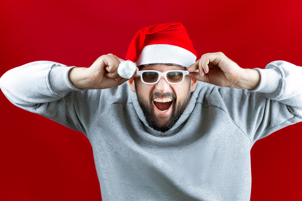 A Bearded Man in a Santa Claus Hat Watches Christmas Movies with